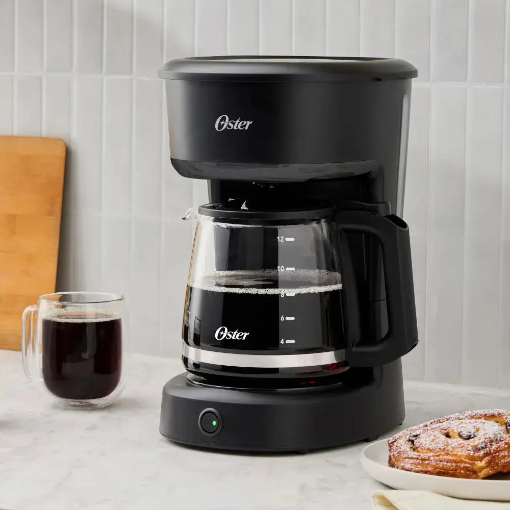 Cafetera filtro sobre mesada de cocina preparando café para varias personas